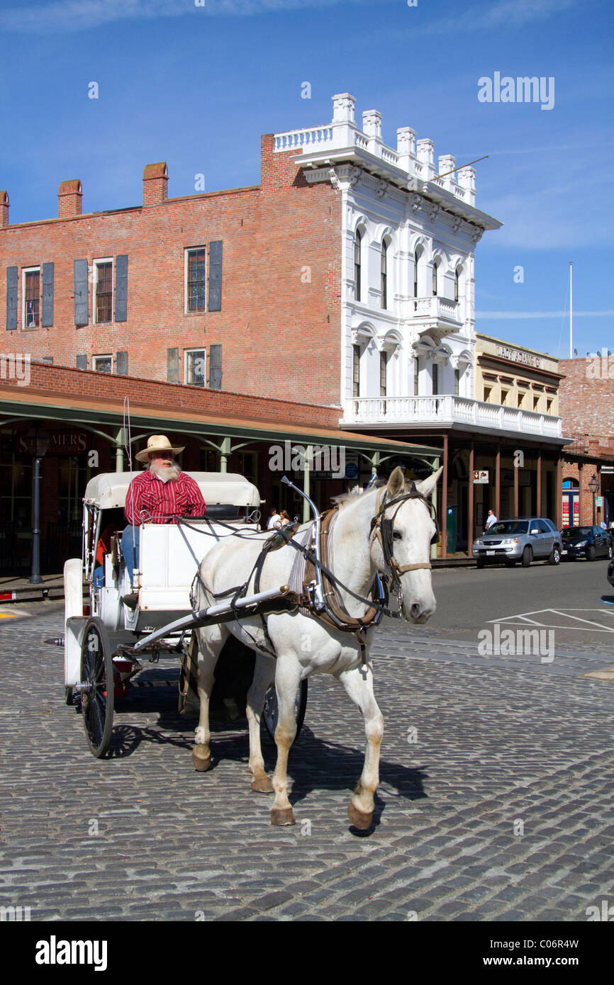 I turisti di marcia in un carro trainato da cavalli a Old Sacramento State Historic Park a Sacramento, Califorina, STATI UNITI D'AMERICA. Foto Stock