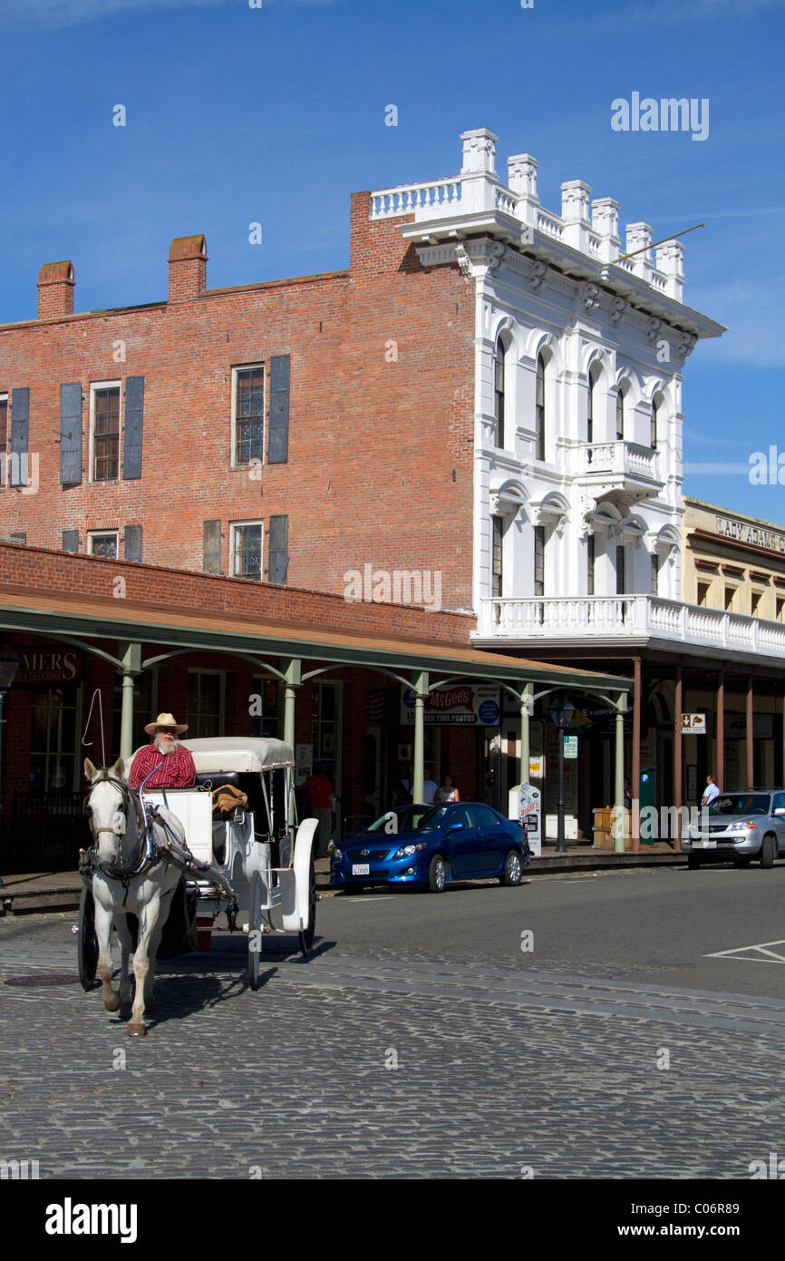 I turisti di marcia in un carro trainato da cavalli a Old Sacramento State Historic Park a Sacramento, California, Stati Uniti d'America. Foto Stock