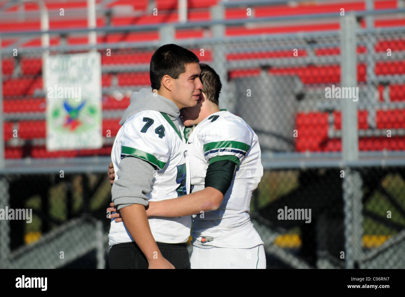 Due di alta scuola calcio giocatori scambiano un abbraccio emotivo a seguito di un post-stagione perdita di spareggio. Stati Uniti d'America. Foto Stock