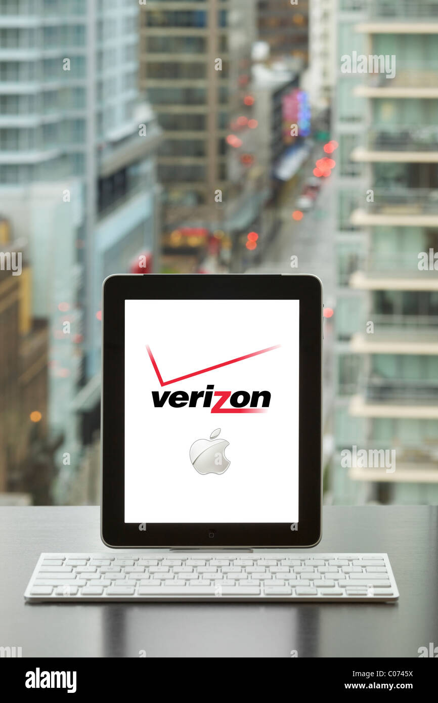 IPad essendo utilizzato in un ufficio con tastiera wireless bluetooth mostra Verizon e logo Apple sullo schermo Foto Stock