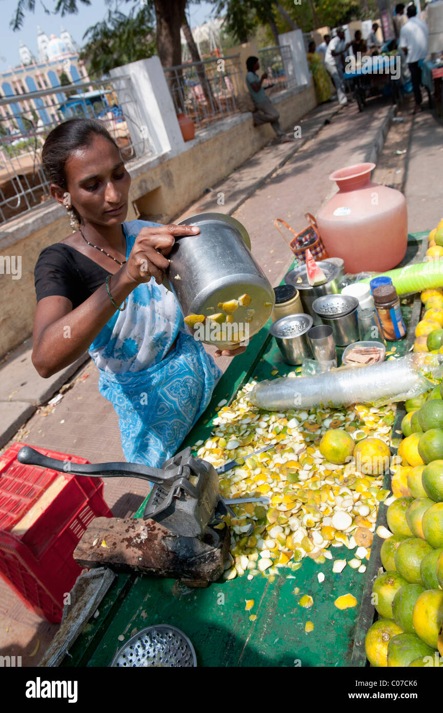 Donna indiana la vendita di spremuta di arance per le strade di Puttaparthi, Andhra Pradesh, India Foto Stock