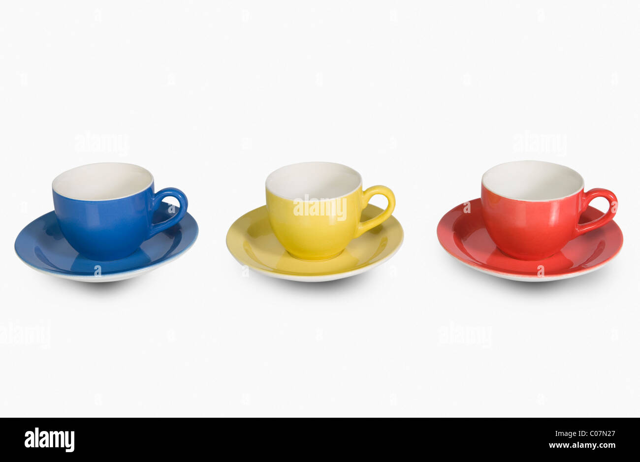 Colorata tazze tè con piattini in una riga Foto Stock