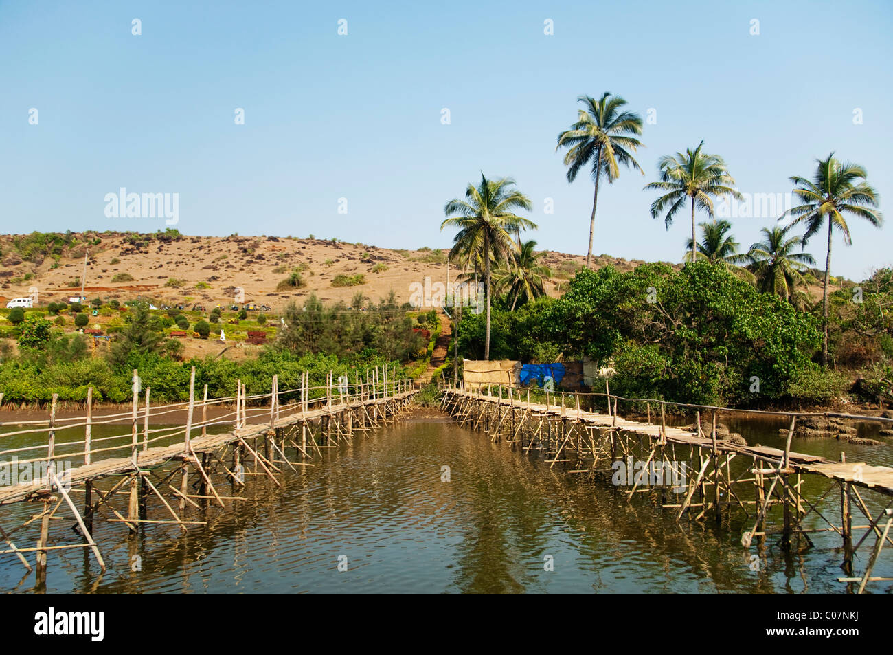 Due ponti in legno attraverso il fiume, Goa, India Foto Stock