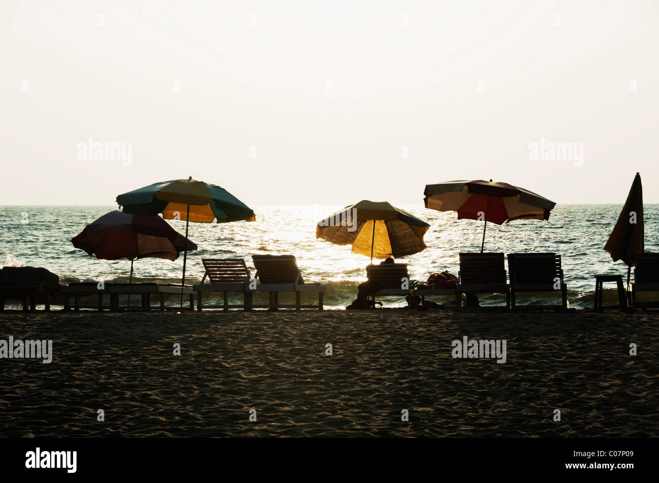 Sedie a sdraio e ombrelloni sulla spiaggia, Goa, India Foto Stock