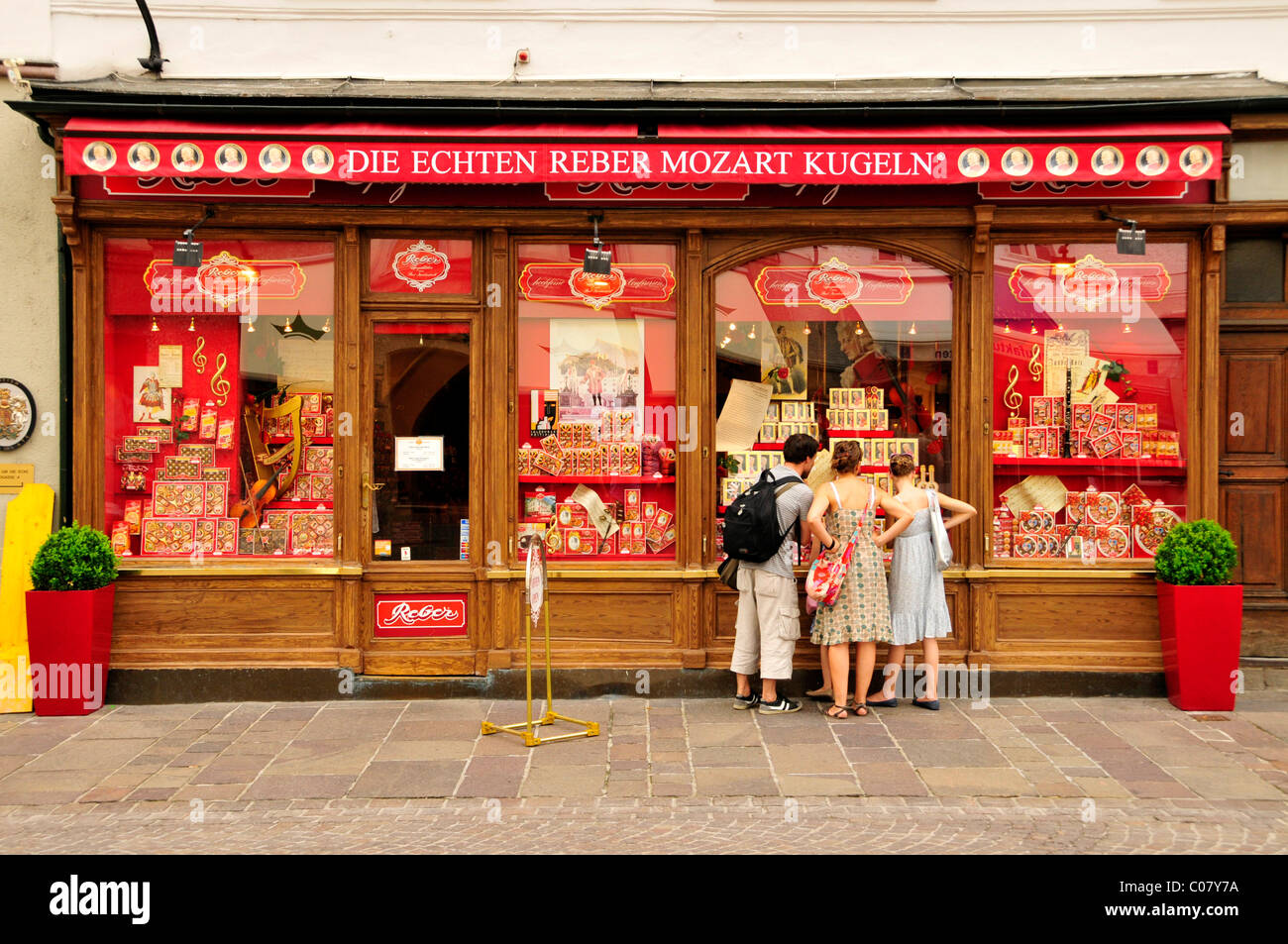 I turisti nella parte anteriore del negozio Reber, uno dei più noti produttori di palle di Mozart, Salisburgo, Salisburgo, Austria Foto Stock