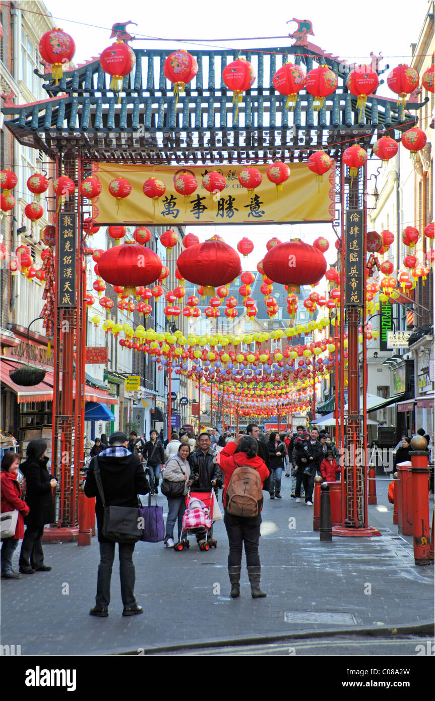 Decorazioni lanterne colorate e persone in Chinatown gateway West End La scena turistica e dello shopping di Londra a Gerrard Street China Town Distretto Inghilterra Regno Unito Foto Stock