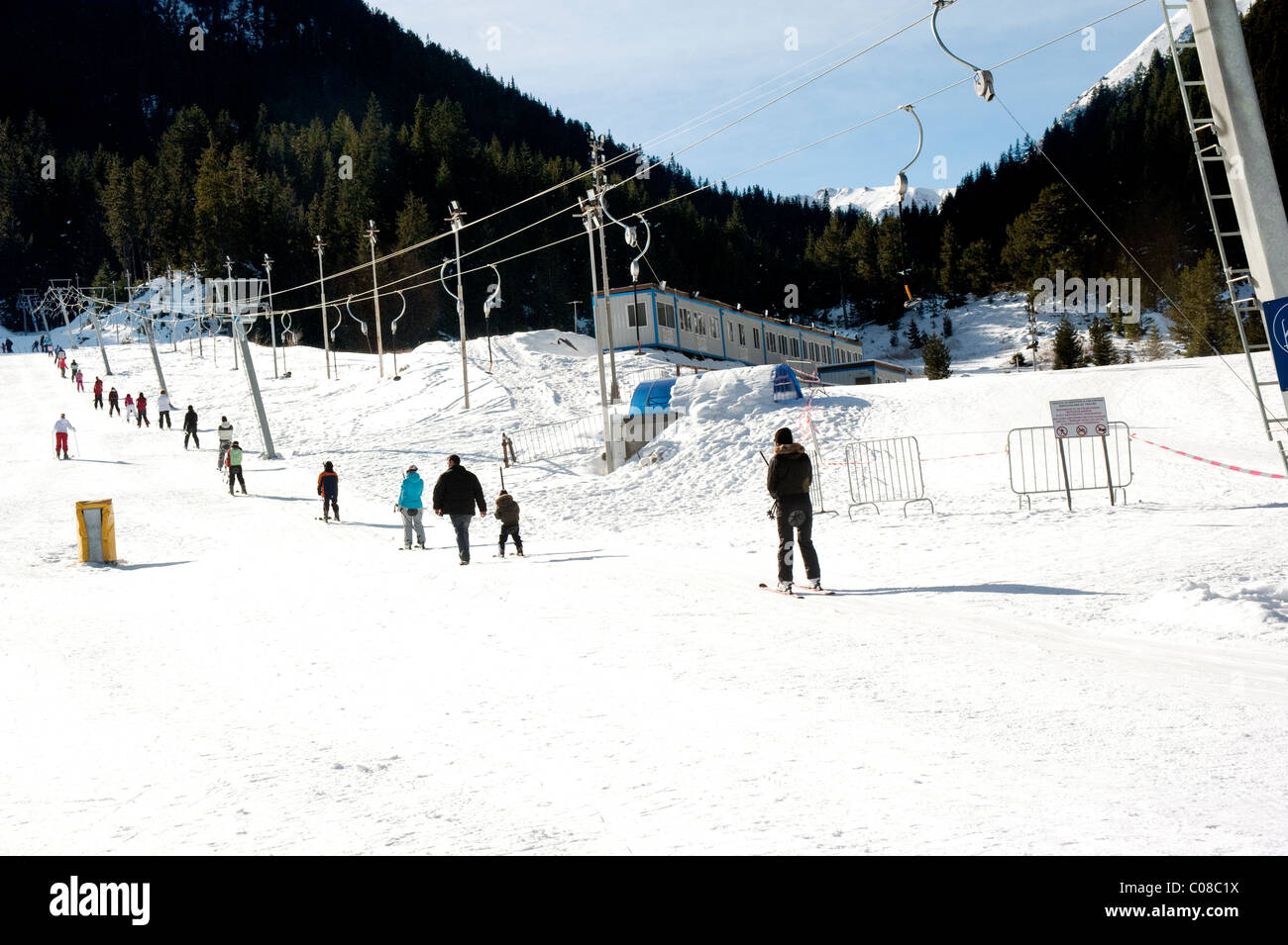 Gli sciatori e snowboarder viene tirato su una barra a T di trainare presso la località sciistica di Bansko in Bulgaria. Foto Stock