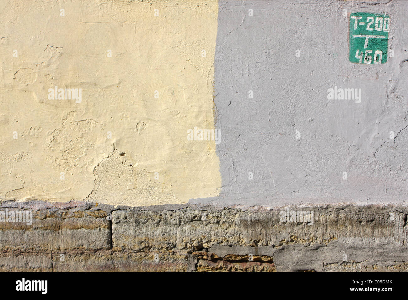 Segno verde su una parete di giallo e grigio colore Foto Stock