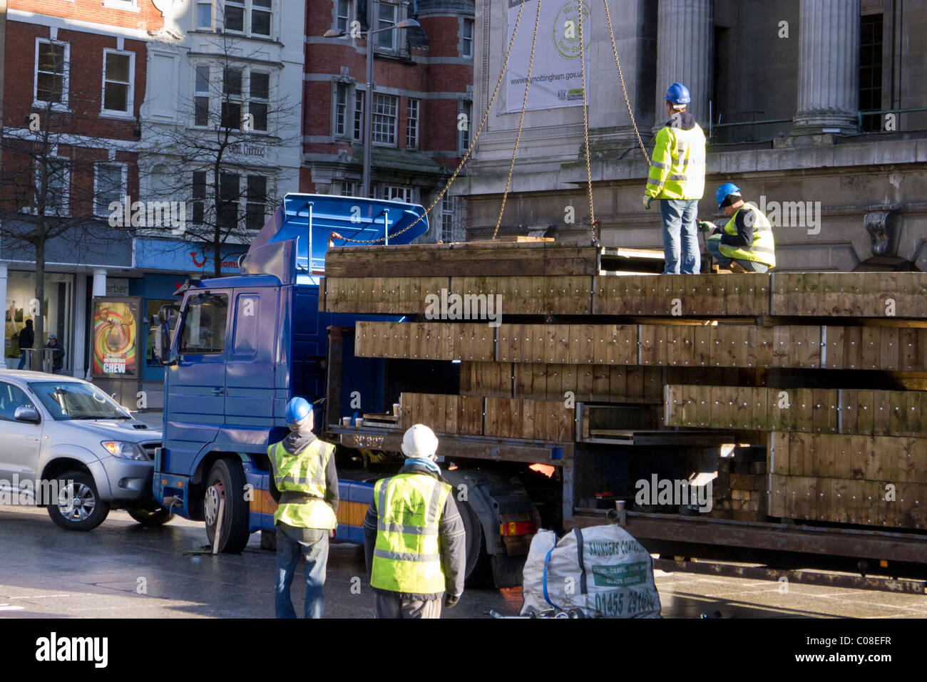 Operai lavorano con una gru e il carrello per preparare nottingham piazza del mercato per la fiera del divertimento a scuola a metà termine febbraio 2011 Foto Stock