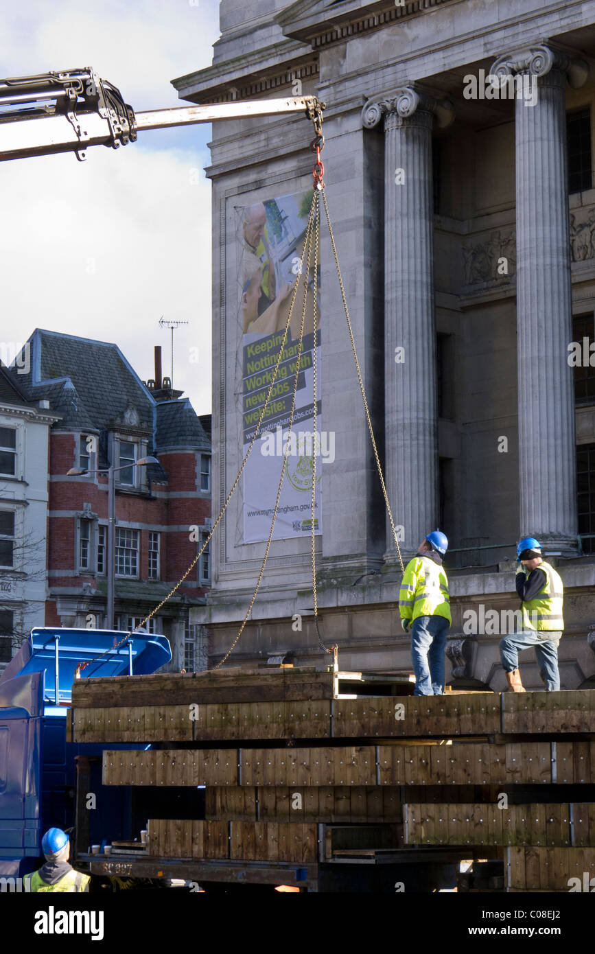 Operai lavorano con una gru e il carrello per preparare nottingham piazza del mercato per la fiera del divertimento a scuola a metà termine febbraio 2011 Foto Stock