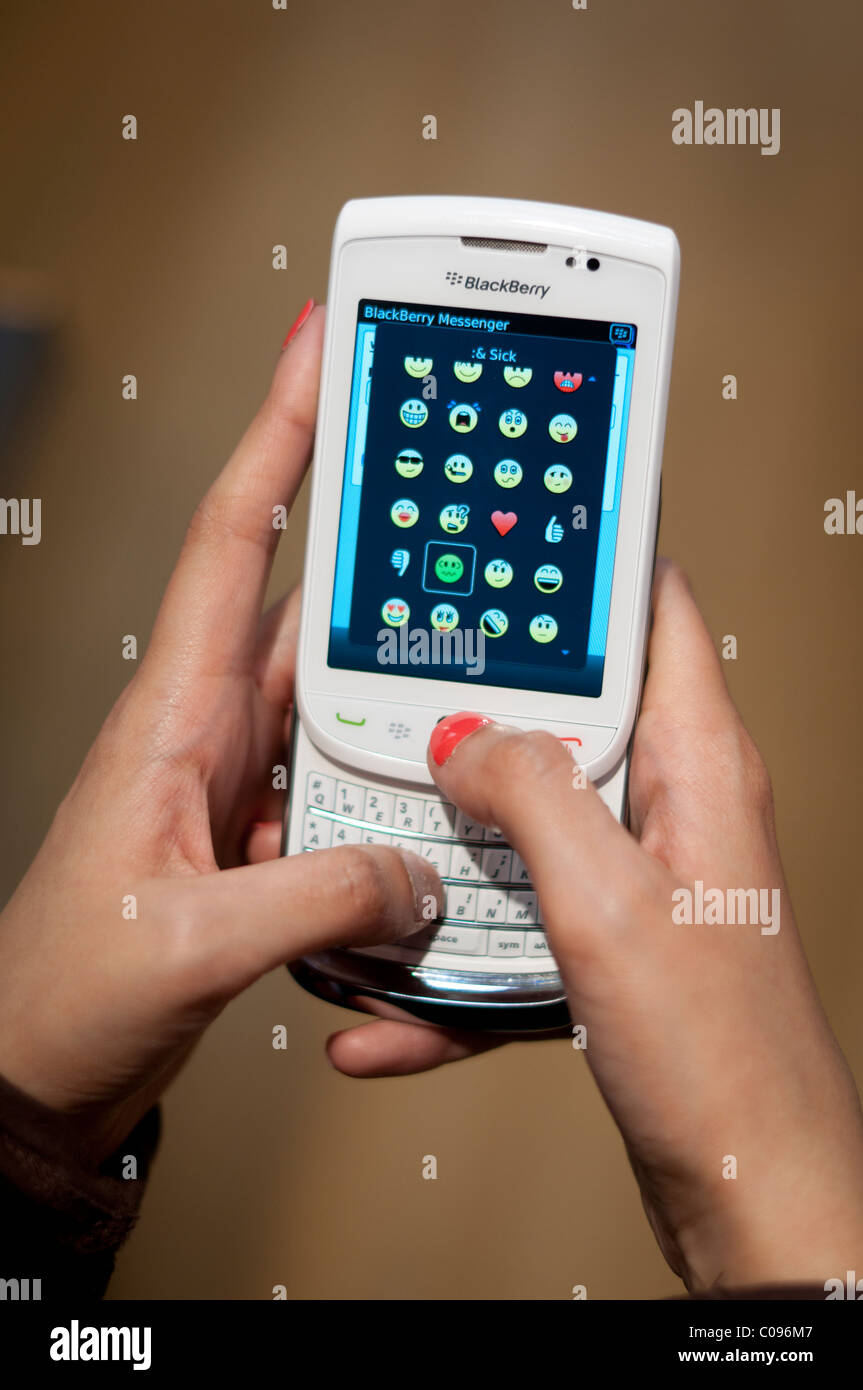Ragazza utilizzando Blackberry messenger su un dispositivo Blackberry 9800 torcia Foto Stock