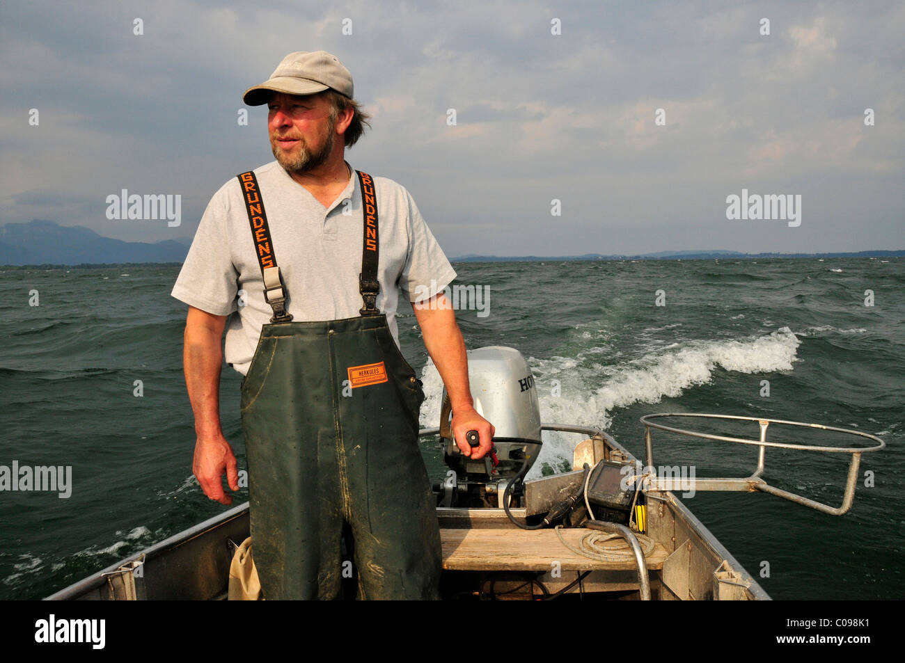 Fisherman Lex Thomas sulla sua barca da pesca vicino all'isola di Fraueninsel, il lago Chiemsee, Chiemgau, Baviera, Germania, Europa Foto Stock