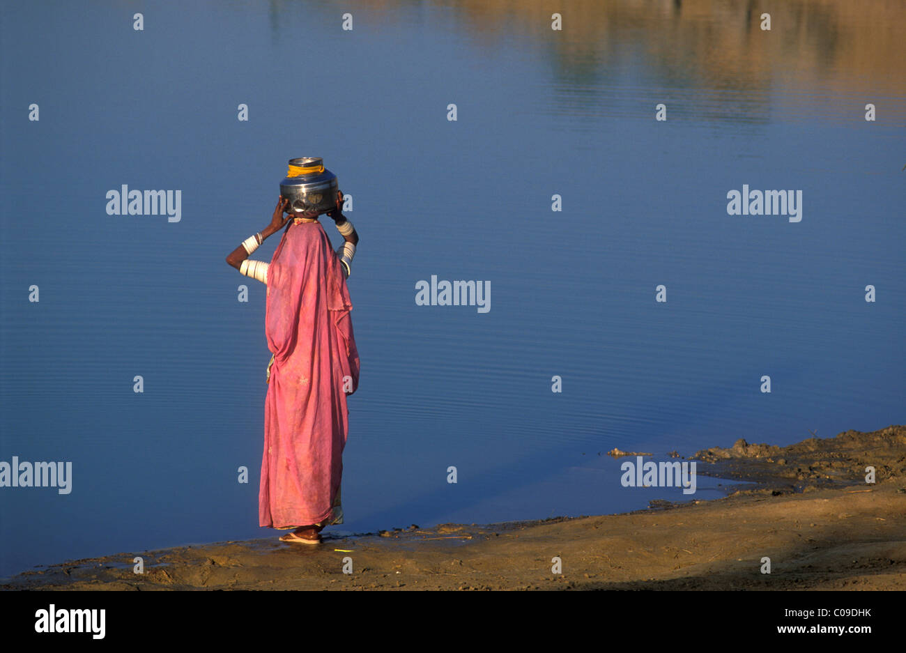 Le donne il recupero di acqua ad una riserva d'acqua lasciata oltre la stagione delle piogge, il Deserto di Thar, Rajasthan, India, Asia Foto Stock