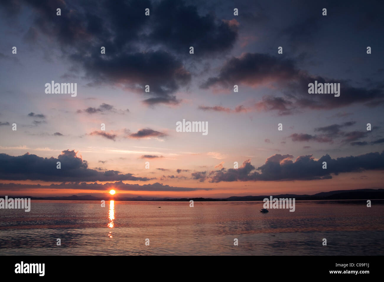 Tramonto con raggi di sole sul lago di Costanza, Hegauberge monti all'orizzonte, Baden-Wuerttemberg, Germania, Europa Foto Stock