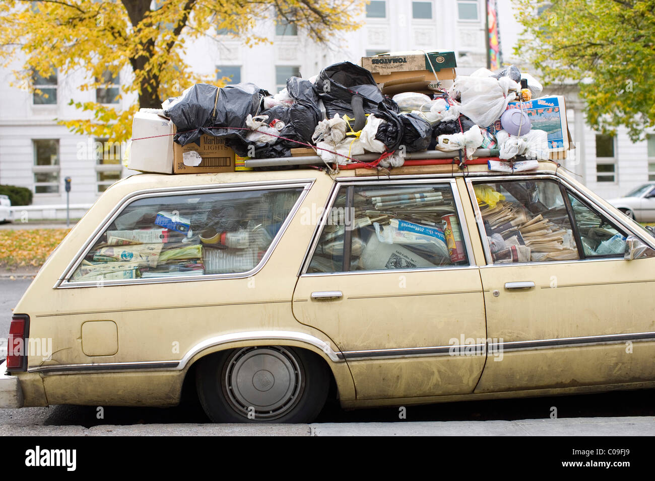 Una macchina parcheggiata riempito di rifiuti e di materiale riciclabile Foto Stock