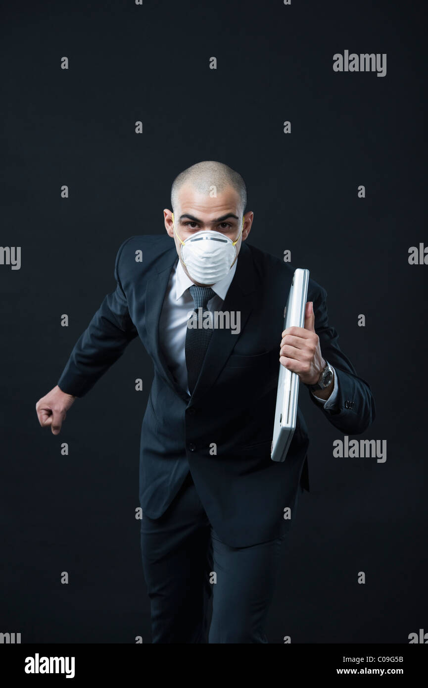 Ritratto di un imprenditore che indossa una maschera di inquinamento e in esecuzione Foto Stock