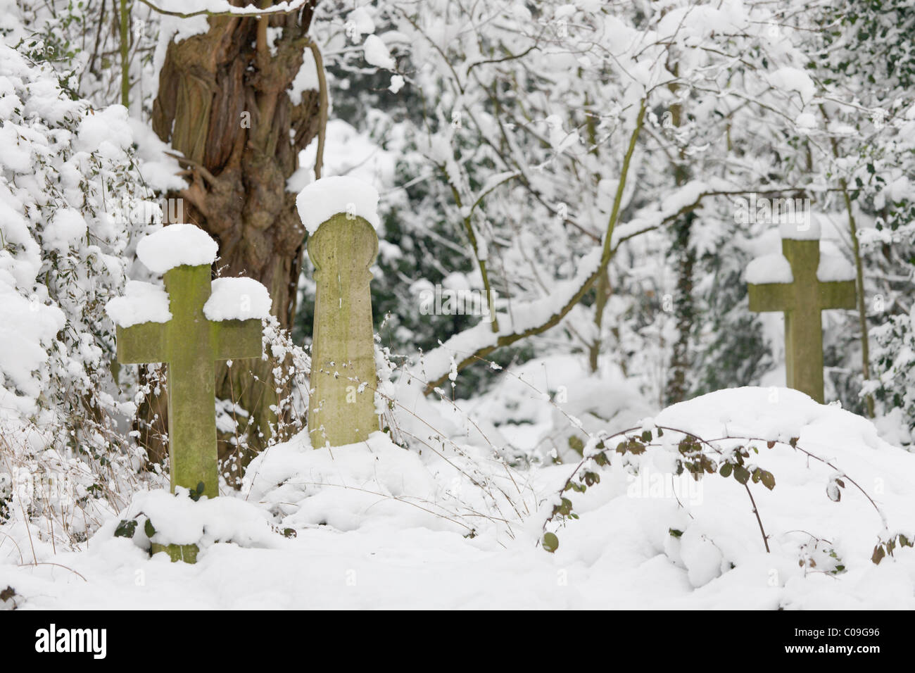 Coperta di neve croci e lapidi presso il vecchio cimitero di Barnes, Londra Foto Stock