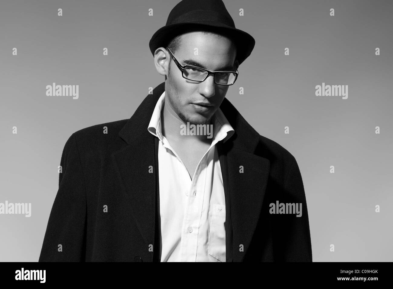 Ritratto di un giovane uomo in una tuta, shirt, camicia e hat Foto Stock