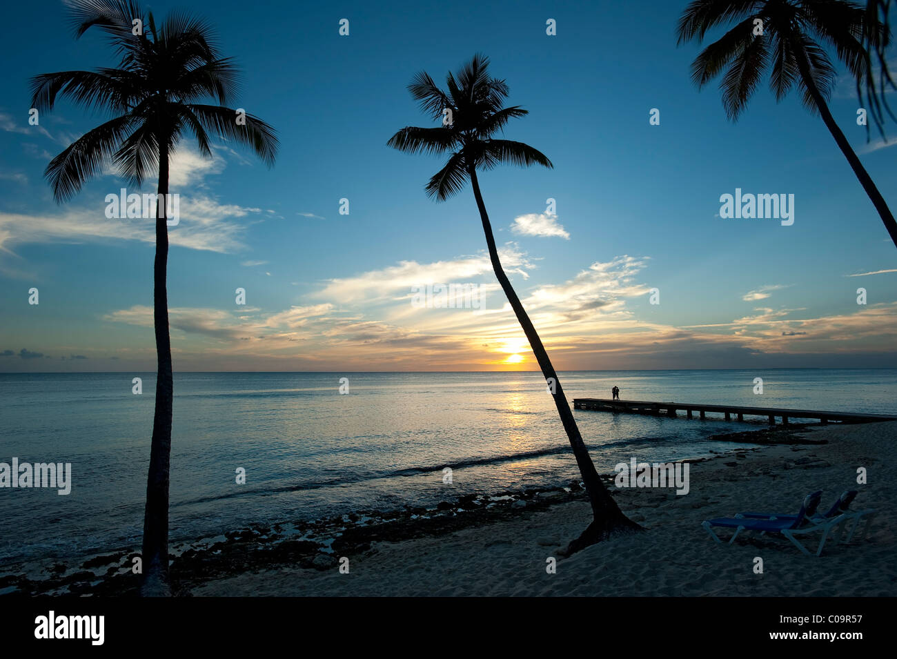 Tramonto con palme e giovane, Bayahibe Beach, Repubblica Dominicana Foto Stock