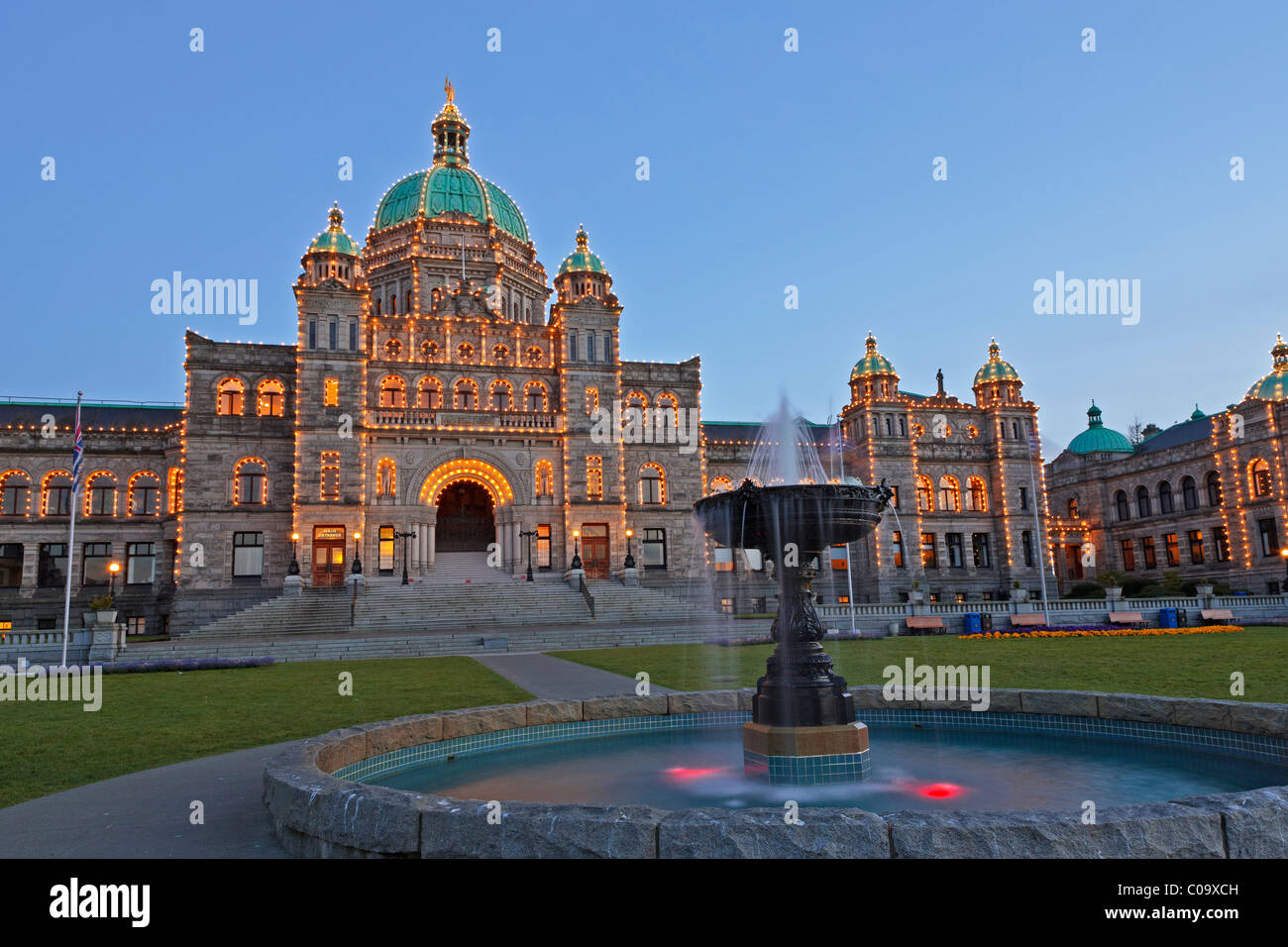 Fontana illuminata di fronte al British Columbia agli edifici del Parlamento al crepuscolo nel Porto Interno di Victoria, BC, può Foto Stock