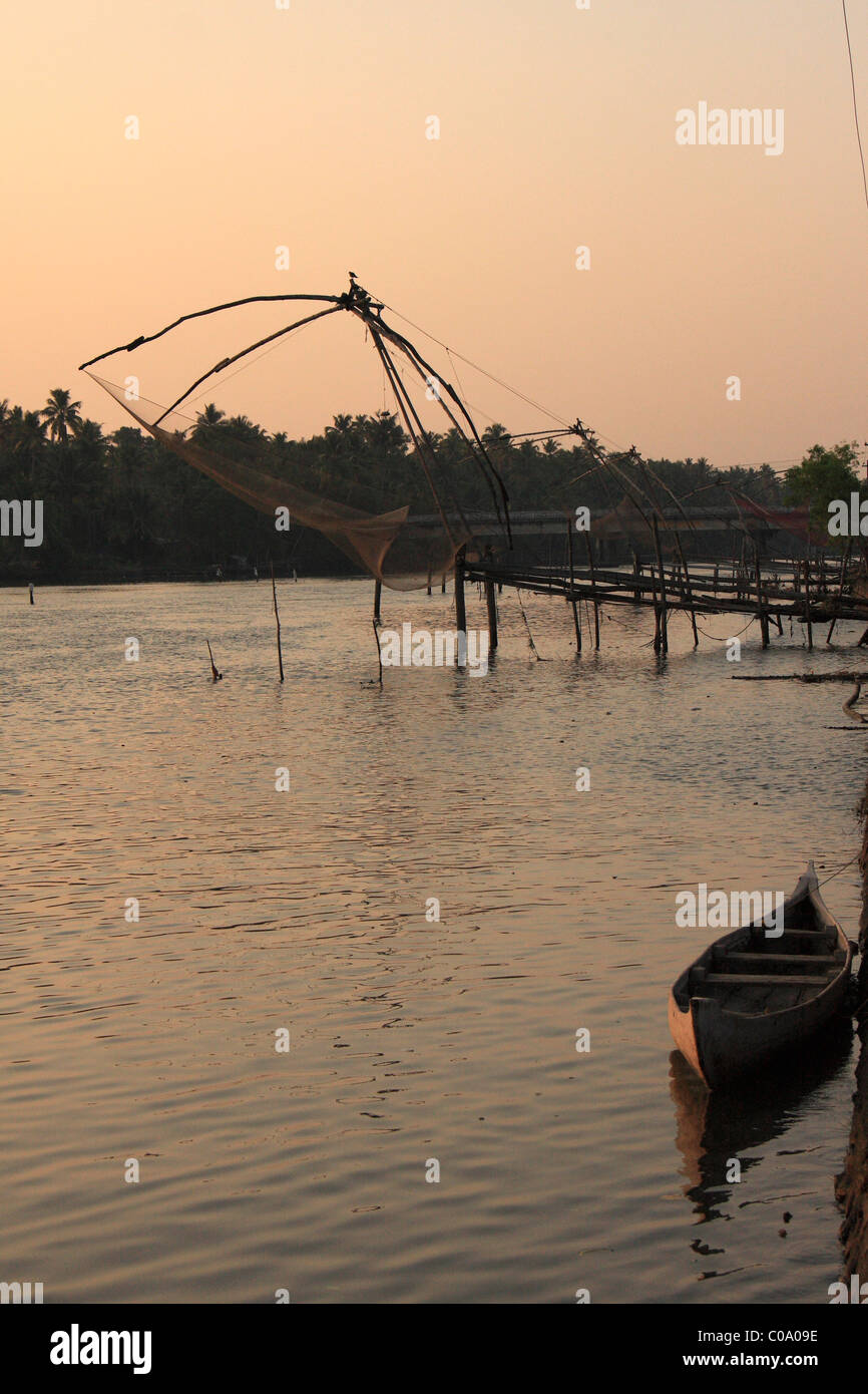 Wooen imbarcazione cinese e reti da pesca nel tramonto, Kerala, India Foto Stock