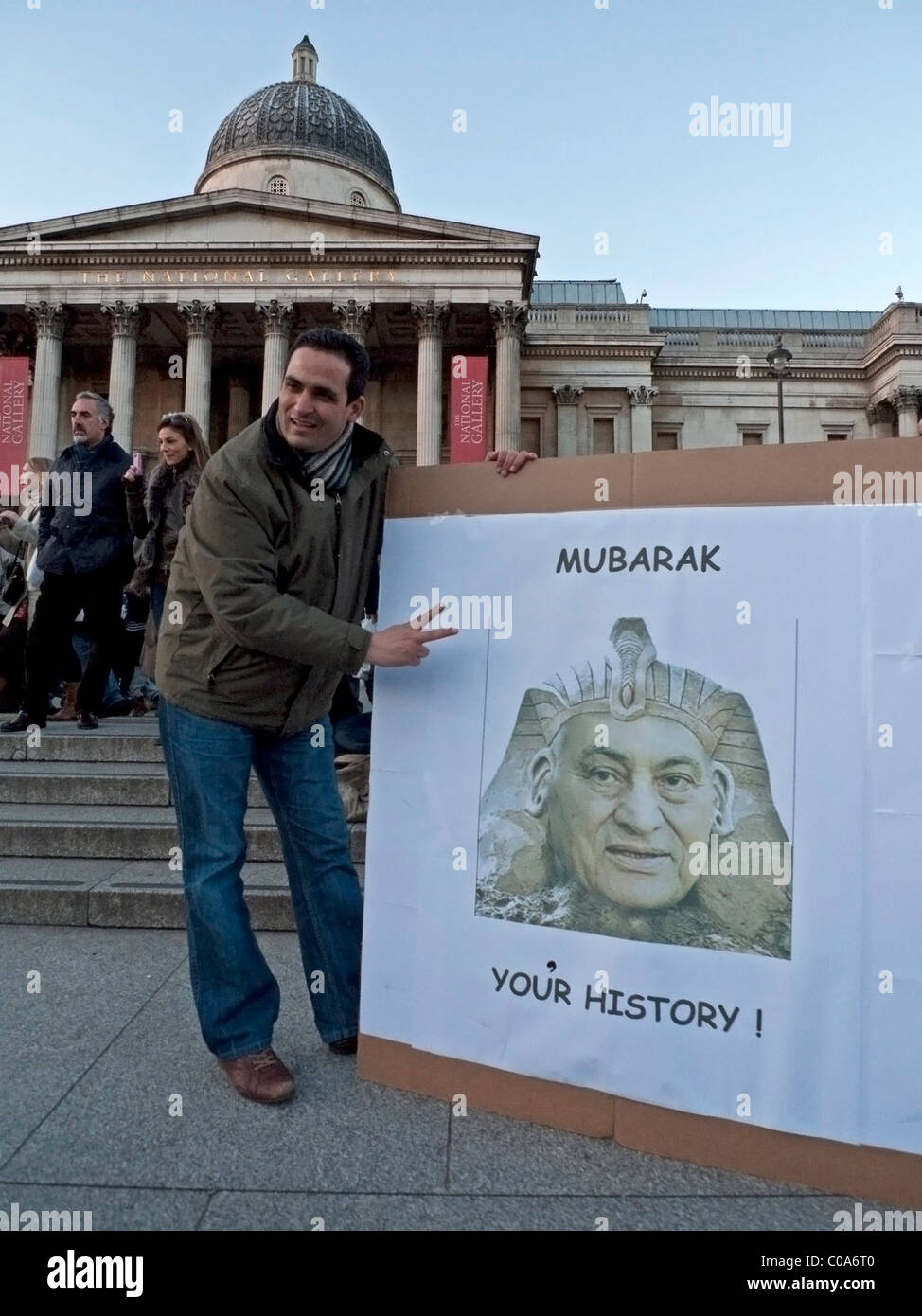 Un uomo egiziano e poster per celebrare la scomparsa del Presidente Mubarak di fronte alla National Gallery di Londra 12 Febbraio 2011 Foto Stock