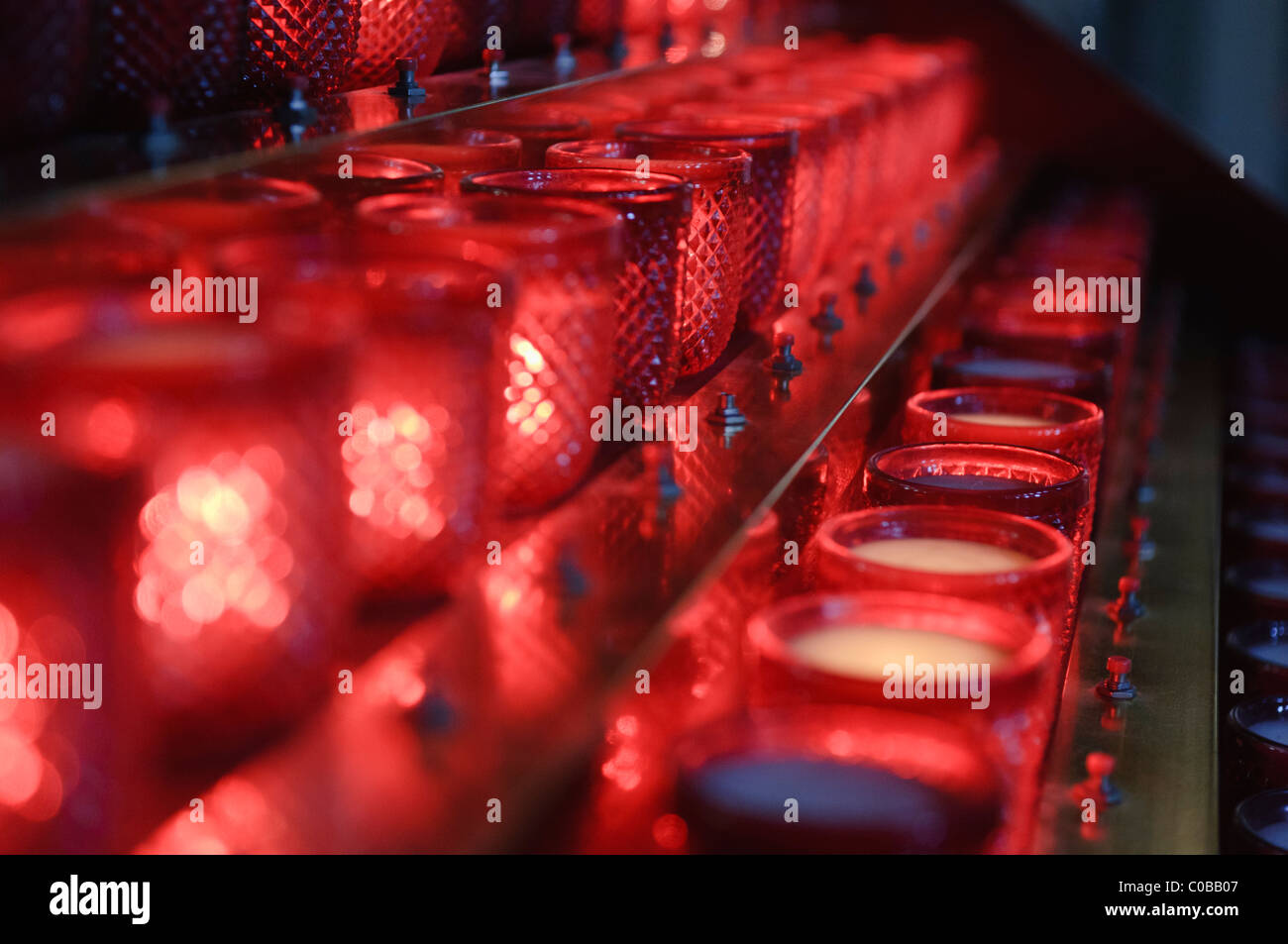 Candele rosso all'interno di vasetti di vetro in una chiesa Foto Stock