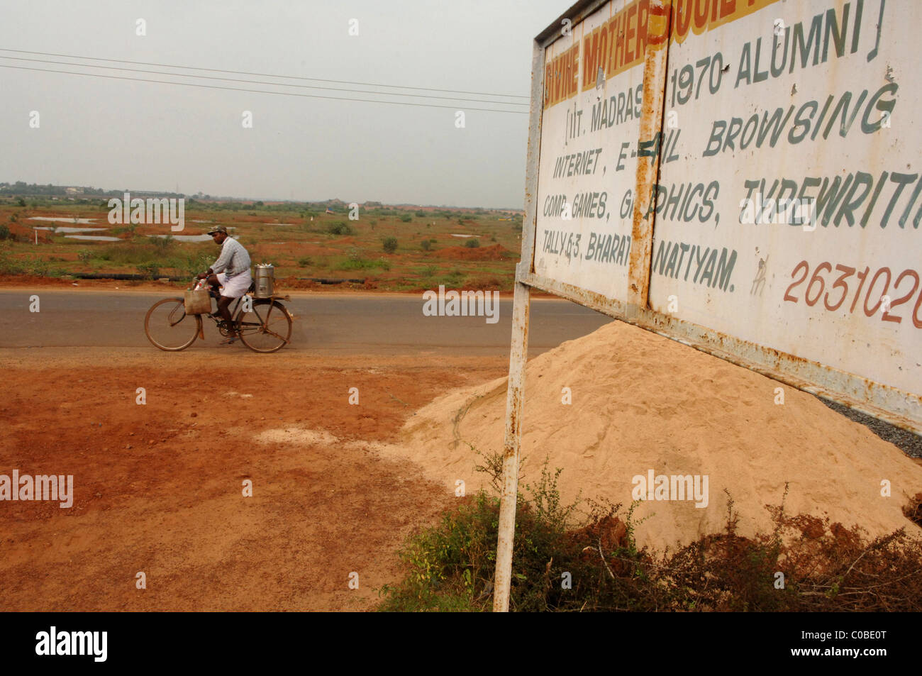 Il crescente divario tra il 'haves' e il 'non abbienti"; è molto stark in India. Un uomo in bicicletta di un passato rurale centro di elearning. Foto Stock