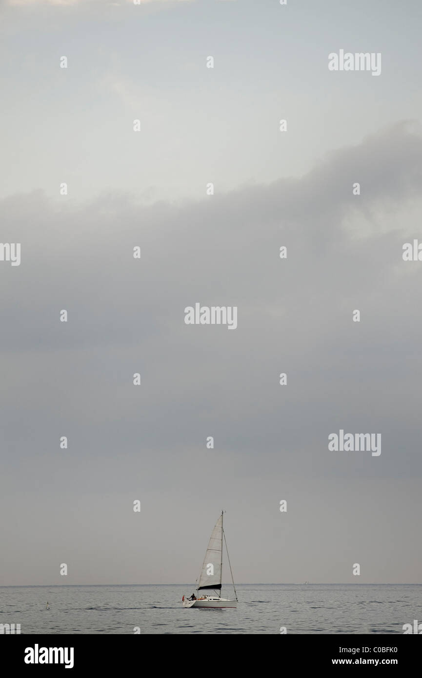 Lone barca a vela nel mar Ligure in Italia Foto Stock