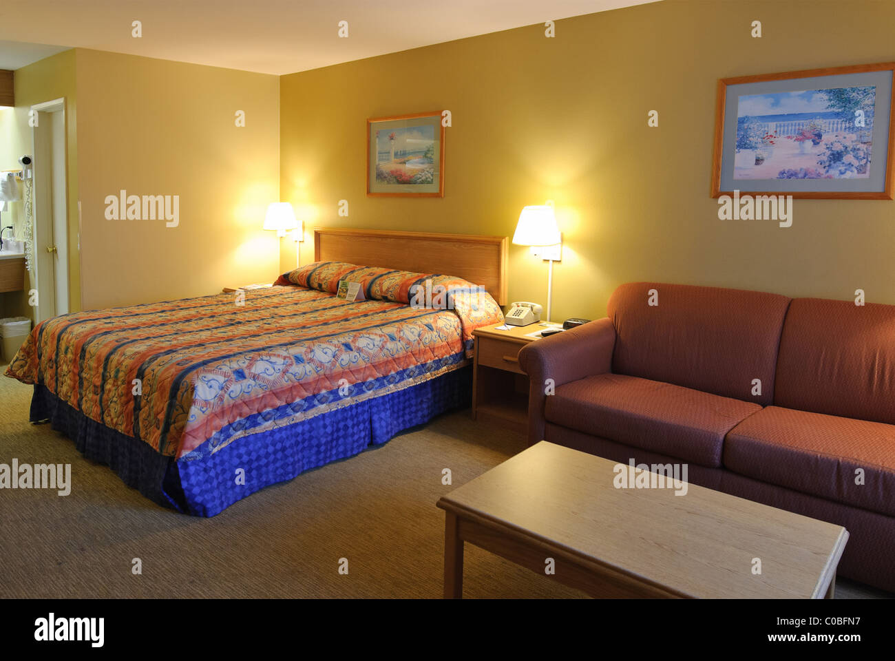 Hotel semplice camera con un letto king size e divano. Foto Stock