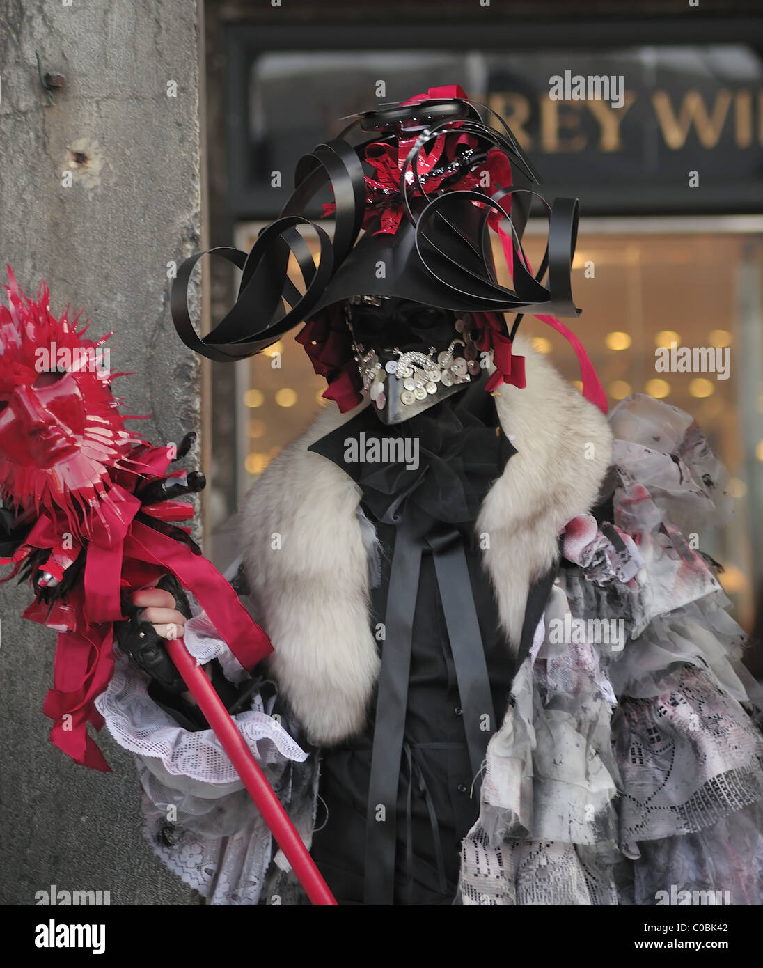 Un membro del pubblico che indossa un costume pone in San Marco davanti alla cerimonia di apertura Foto Stock