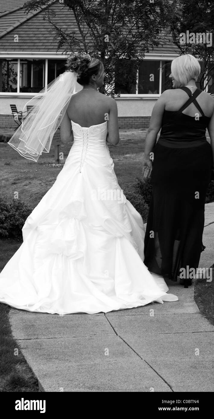 Immagine monocromatica di una sposa parlando a un ospite AL SUO MATRIMONIO Foto Stock