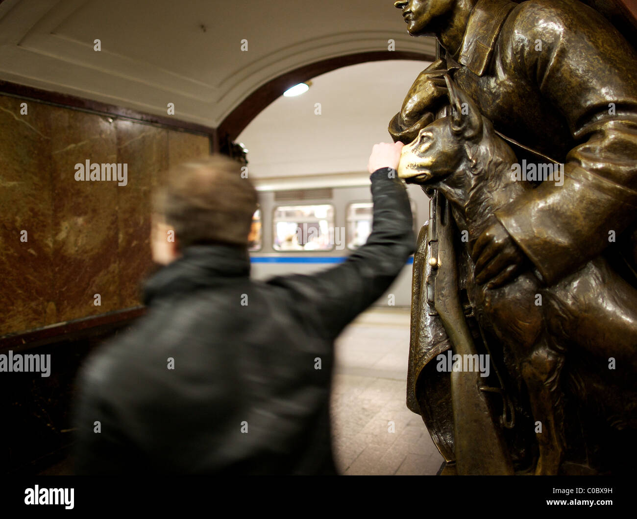 Superstiziosi Muscovite tocca per buona fortuna il naso di una statua di un cane a Ploshchad Revolyutsii la stazione della metropolitana di Mosca Foto Stock