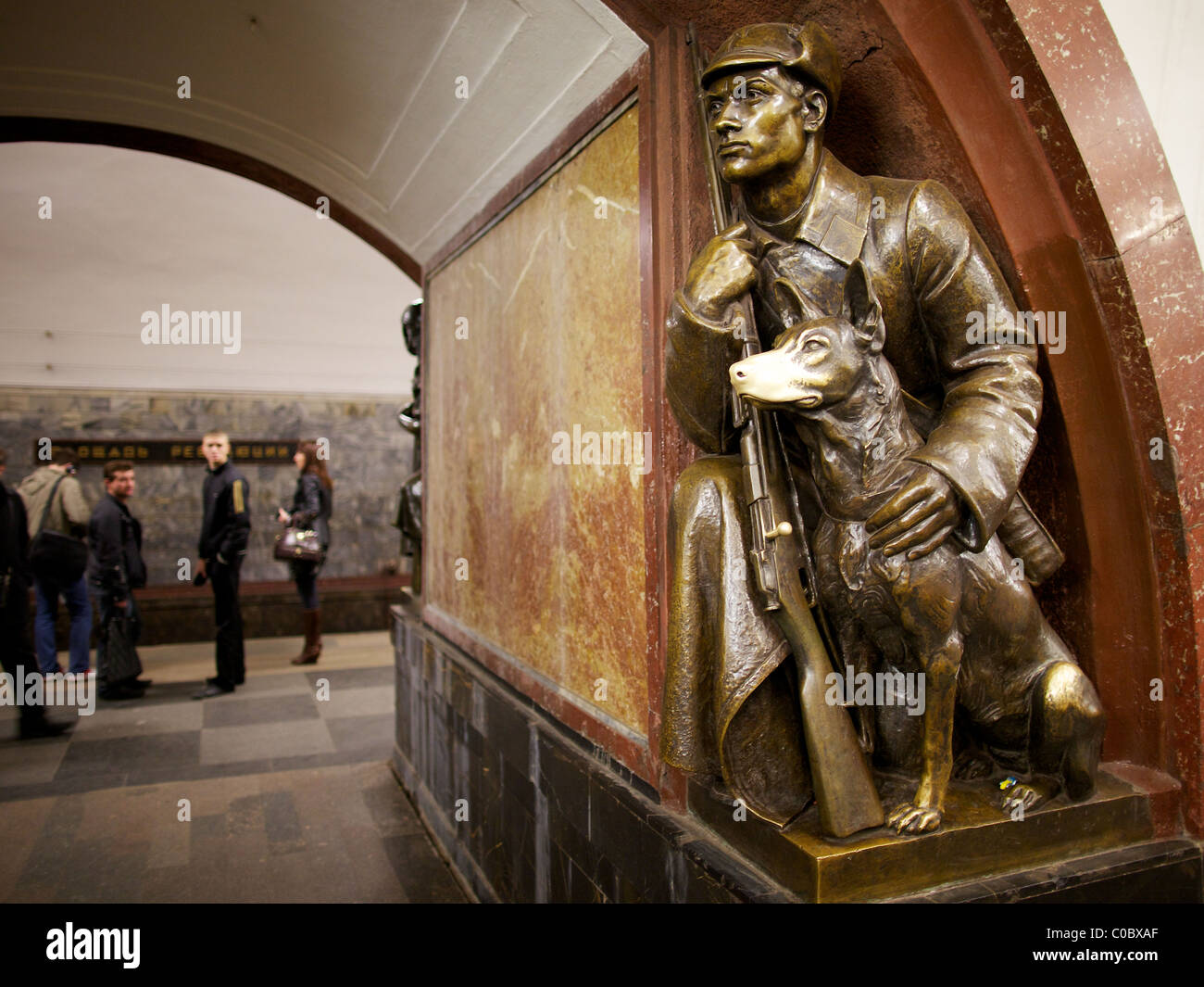 Superstiziosi moscoviti touch per buona fortuna il naso lucido di una statua di un cane a Ploshchad Revolyutsii la stazione della metropolitana di Mosca Foto Stock