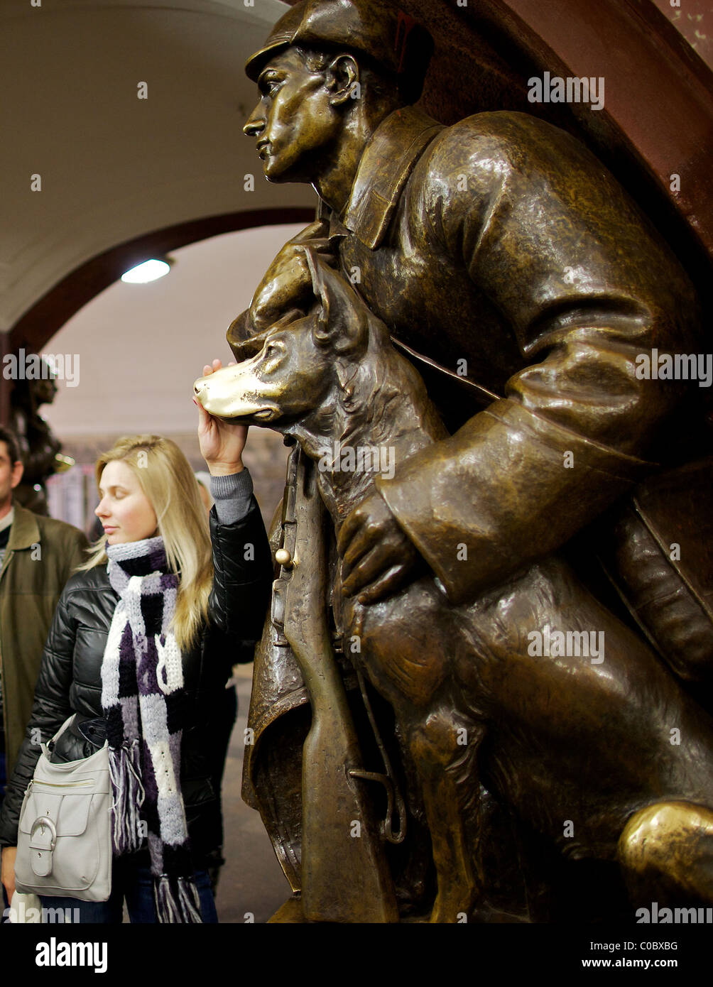 Superstiziosi Muscovite tocca per buona fortuna il naso di una statua di un cane a Ploshchad Revolyutsii la stazione della metropolitana di Mosca Foto Stock
