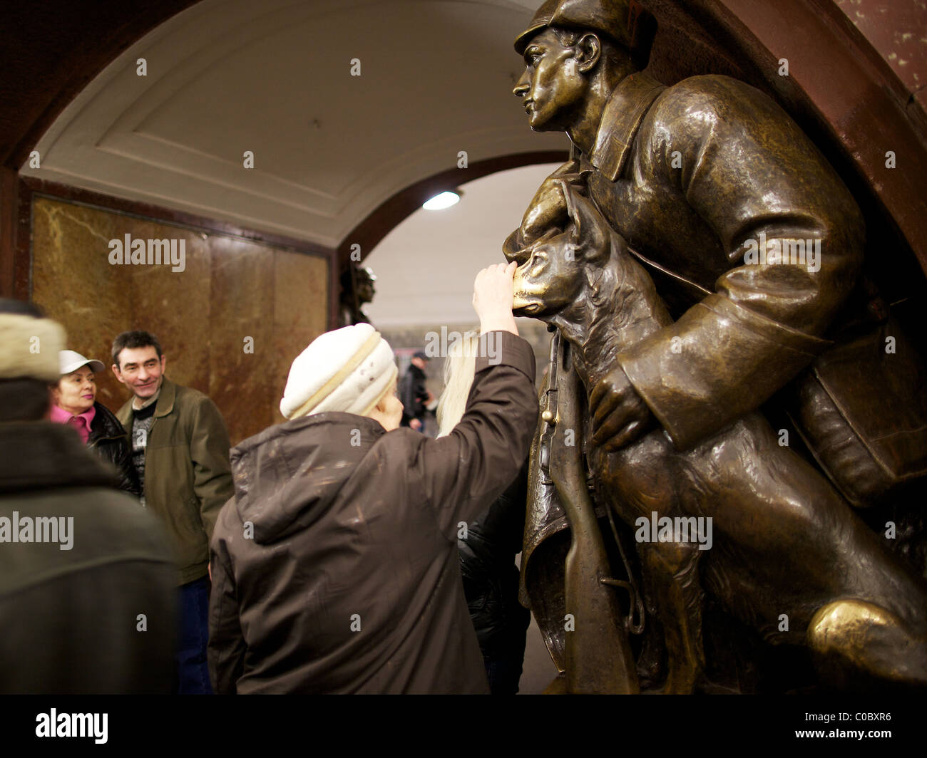 Superstiziosi Muscovite tocca per buona fortuna il naso di una statua di un cane a Ploshchad Revolyutsii la stazione della metropolitana di Mosca Foto Stock