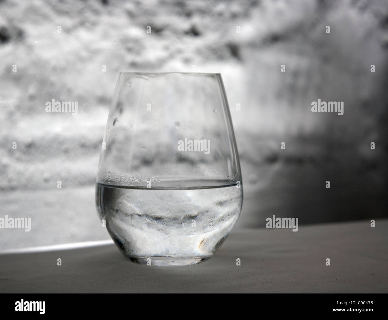 Bicchiere di acqua sulla tovaglia Foto Stock