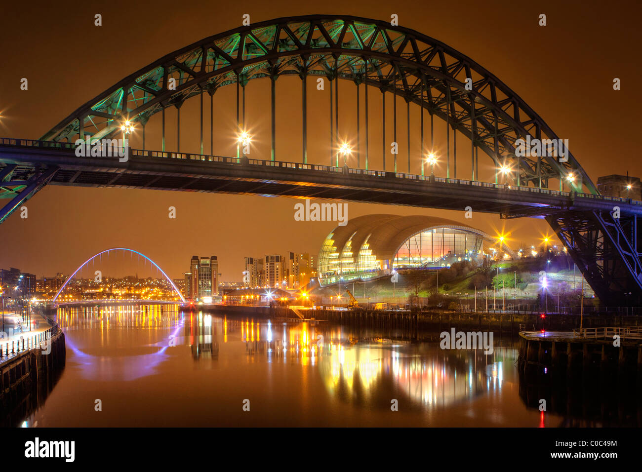 Tyne Bridge di notte in/Newcastle Gateshead attraverso il Fiume Tyne (Millemium Bridge e salvia visibile in background) Foto Stock