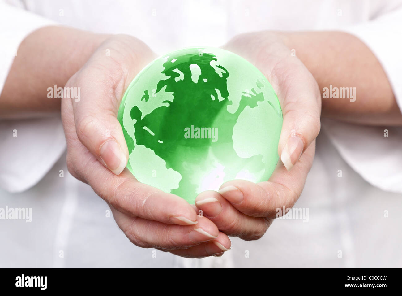 Foto di una donna tenendo un gree globo di vetro nelle sue mani, il concetto di immagine di tutto il mondo per il ambiente globale e temi correlati. Foto Stock