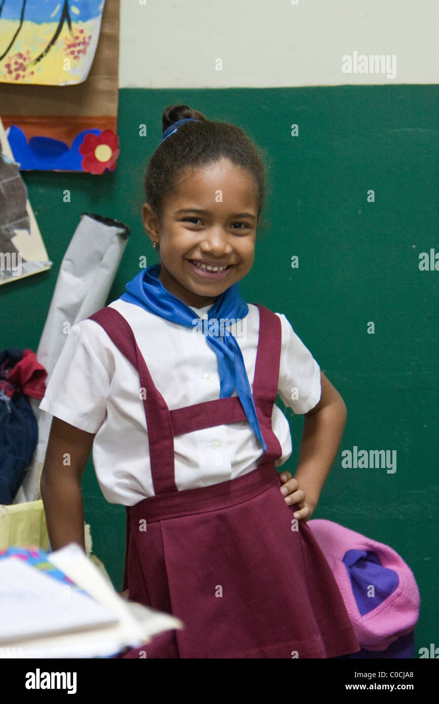 Cuba, La Habana. Ragazza nella scuola primaria della classe. Rosso e bianco sono i colori per la scuola primaria di uniformi. Foto Stock