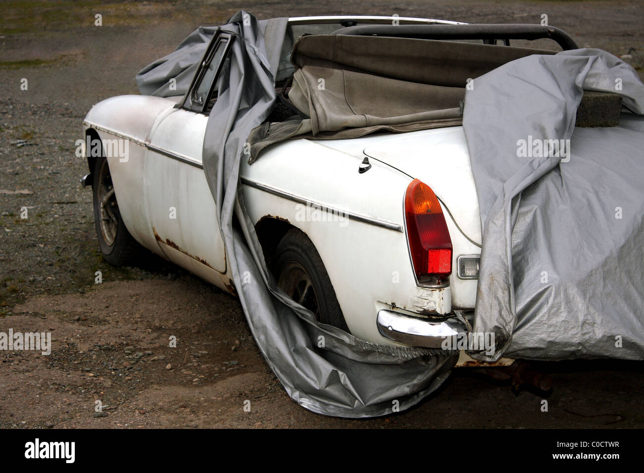 Un vecchio classico bianco MG auto coperti e pronto per essere riparato come un progetto di restauro Foto Stock
