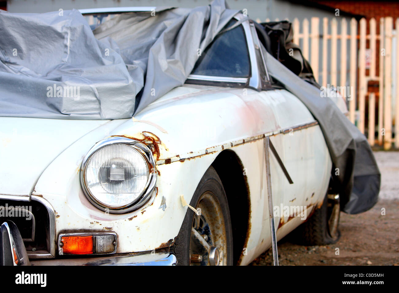 Un vecchio classico bianco MG auto coperti e pronto per essere riparato come un progetto di restauro Foto Stock