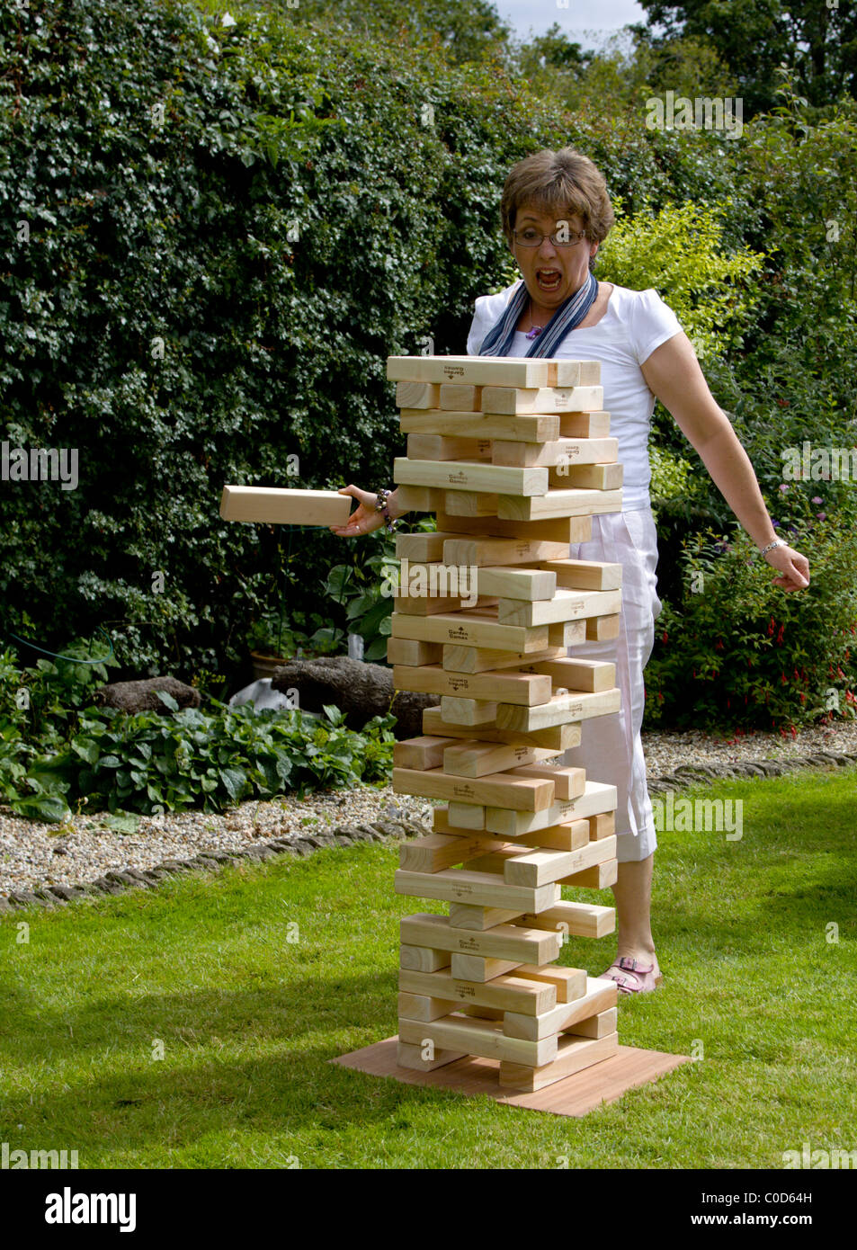 Donna che gioca Jenga gigante gioco in giardino Foto stock - Alamy