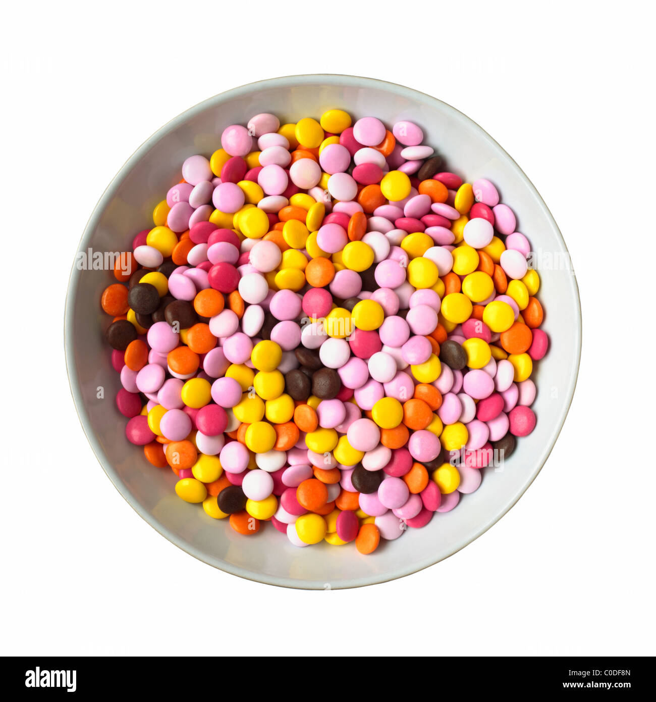 Una ciotola di caramelle cioccolatini rivestiti su uno sfondo bianco Foto Stock