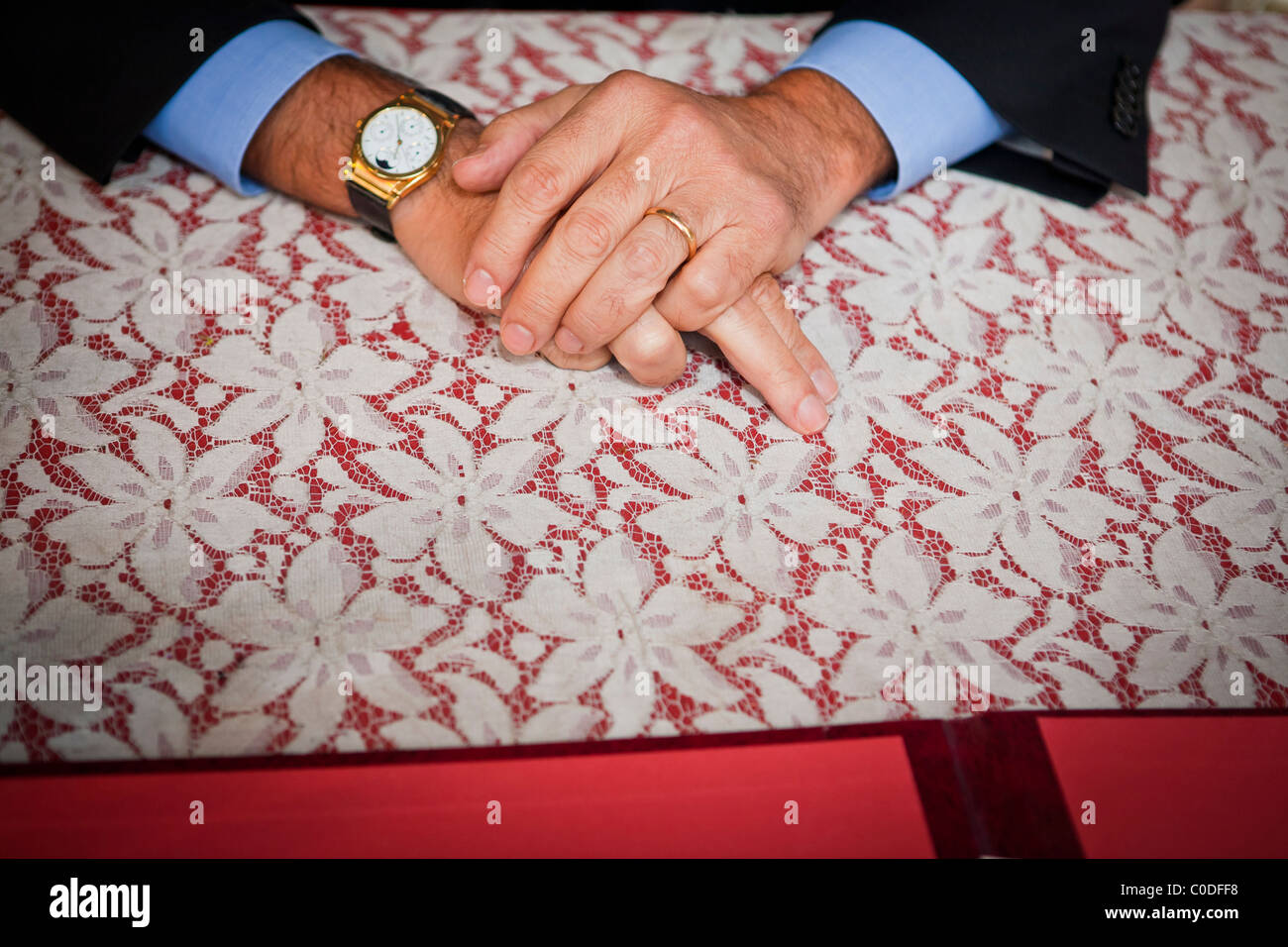 Uomo che indossa l'anello nuziale e appoggio le mani sul tavolo, close up Foto Stock