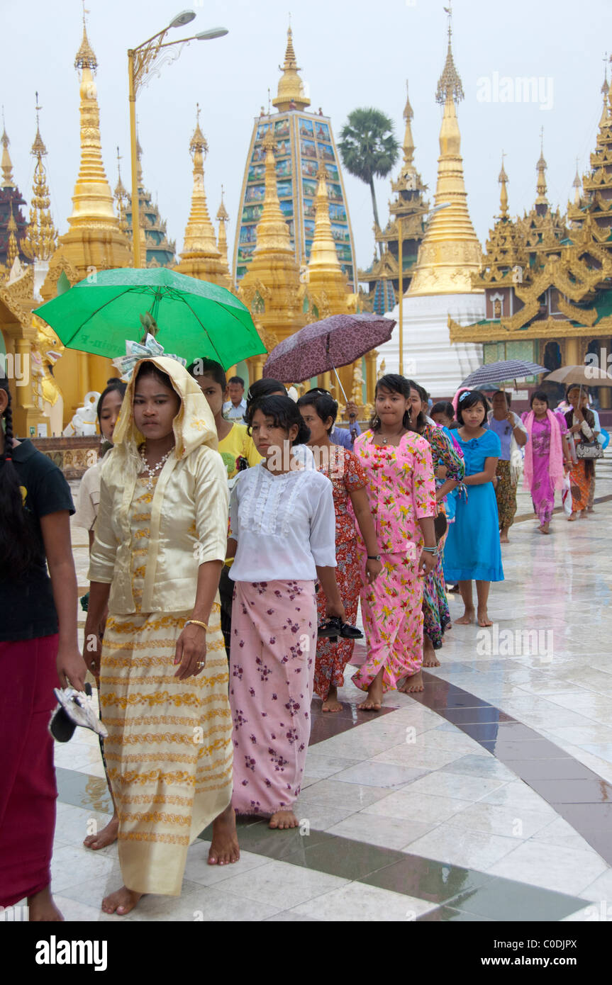 Myanmar (aka Birmania), Yangon (aka Rangoon). Stupa Shewedagon. Cerimonia Novication o Shinbyu processione di donne con offerte. Foto Stock