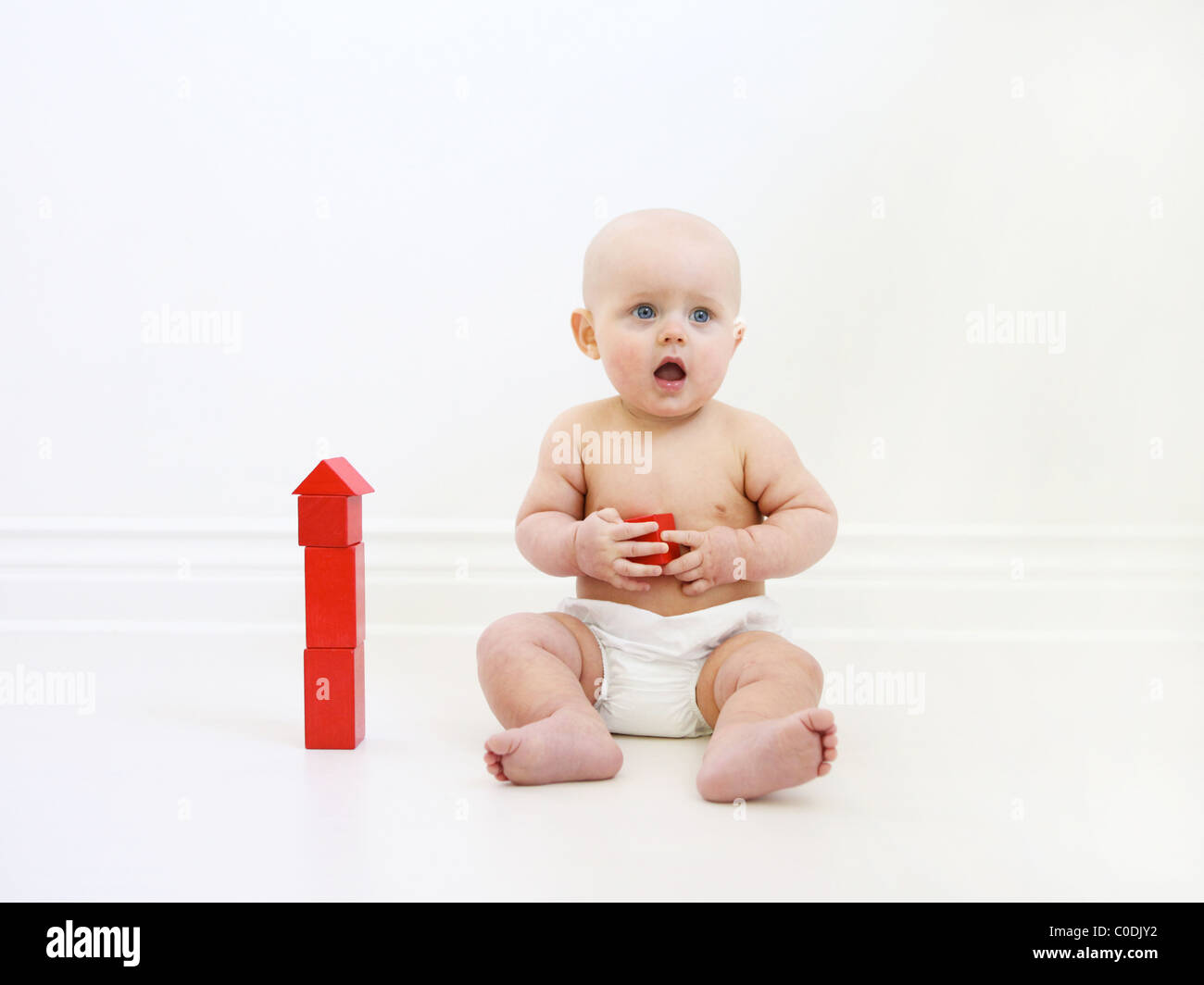 Il bambino gioca con blocchi di colore rosso Foto Stock