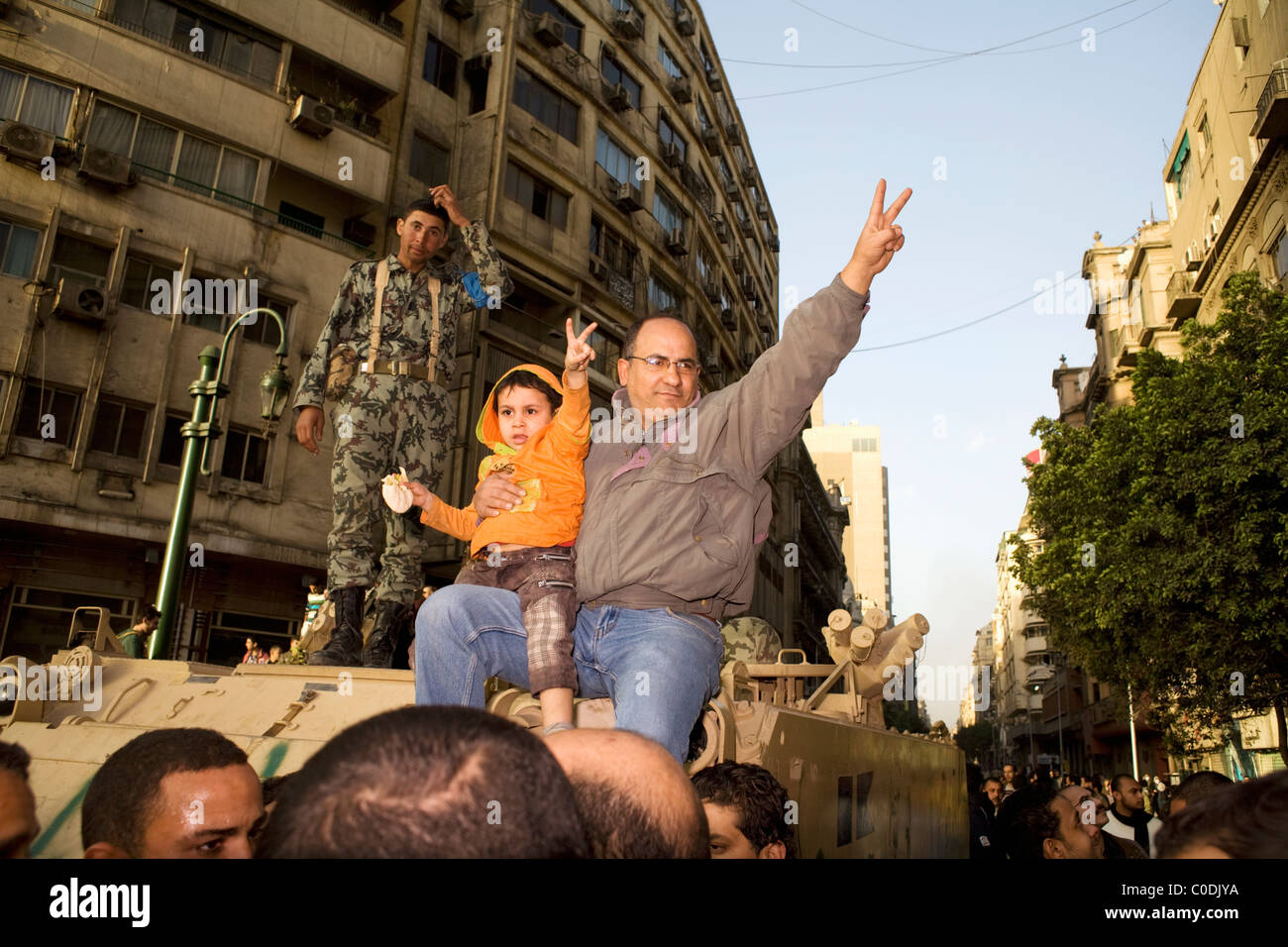 Un uomo e un bambino dà il segno di pace durante le proteste contro il governo del Cairo in Egitto Piazza Tahrir su GEN29, 2011 Foto Stock