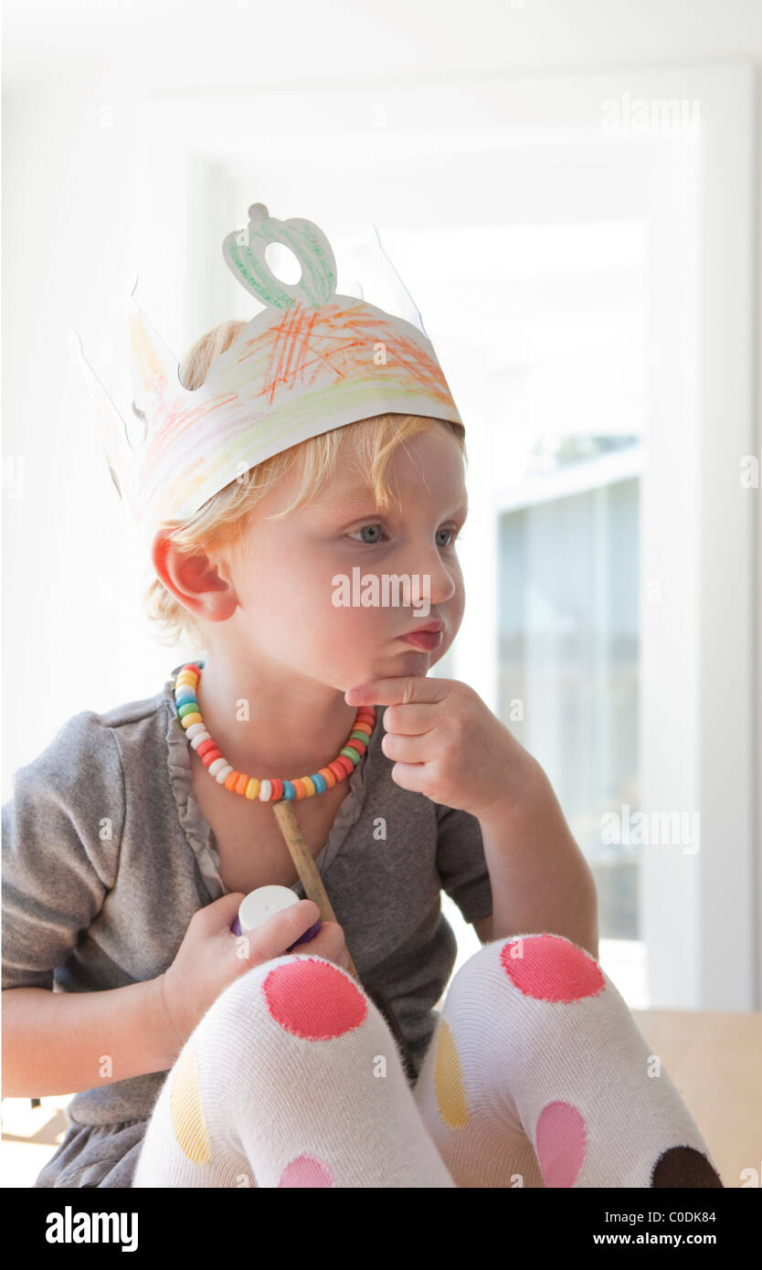 Bambina con corona in casa e candy collana Foto Stock
