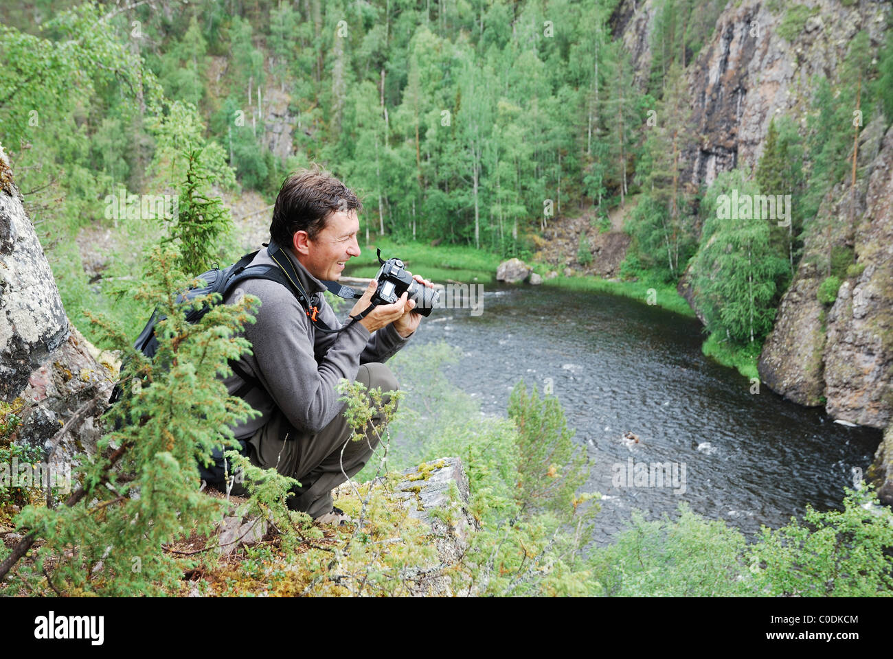 Uomo felice con la fotocamera sulla parte superiore della taiga forest. Foto Stock